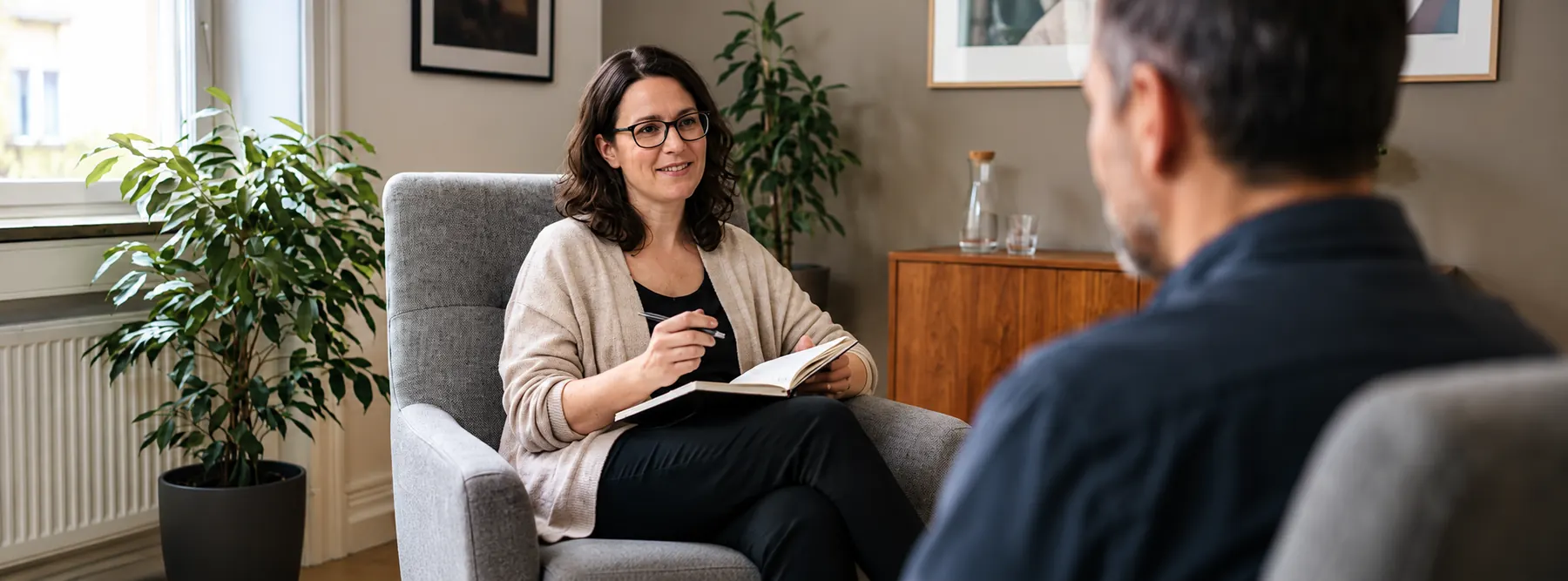 An adviser taking notes in a calm office client conversation